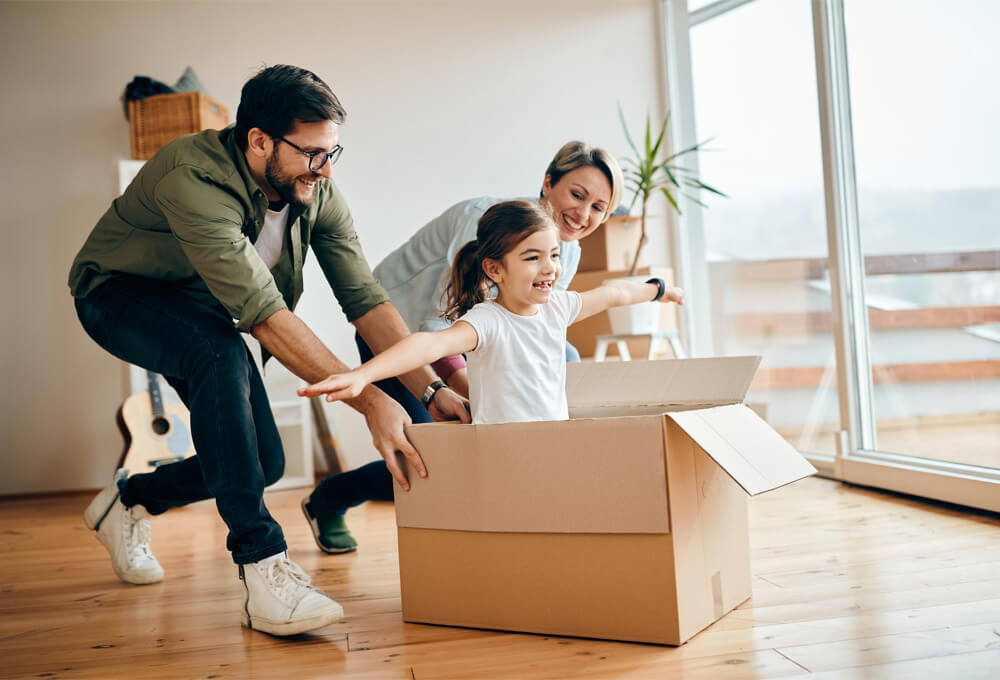 Family carrying boxes into their new home