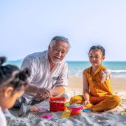 Grandfather playing with his grandchildren on the beach