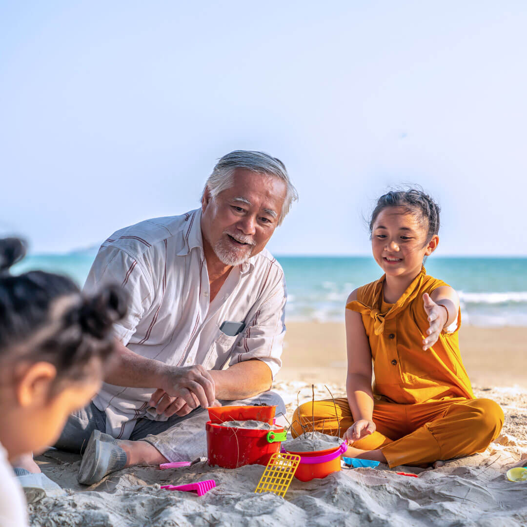 Grandfather playing with his grandchildren on the beach